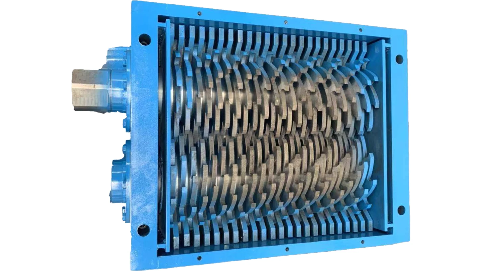 La imagen muestra un tipo de máquina trituradora industrial, concretamente una trituradora de cizalla rotativa. Esta máquina cuenta con un conjunto de cuchillas contrarrotativas con dientes en forma de gancho que están diseñadas para tirar del material hacia la cámara de corte, triturando y reduciendo efectivamente el tamaño del material procesado. El marco azul alrededor de la trituradora indica la construcción resistente típica de este tipo de equipos, que se utilizan con fines de reciclaje o gestión de residuos, como el procesamiento de plásticos, metales o materiales de desecho en fragmentos más pequeños.