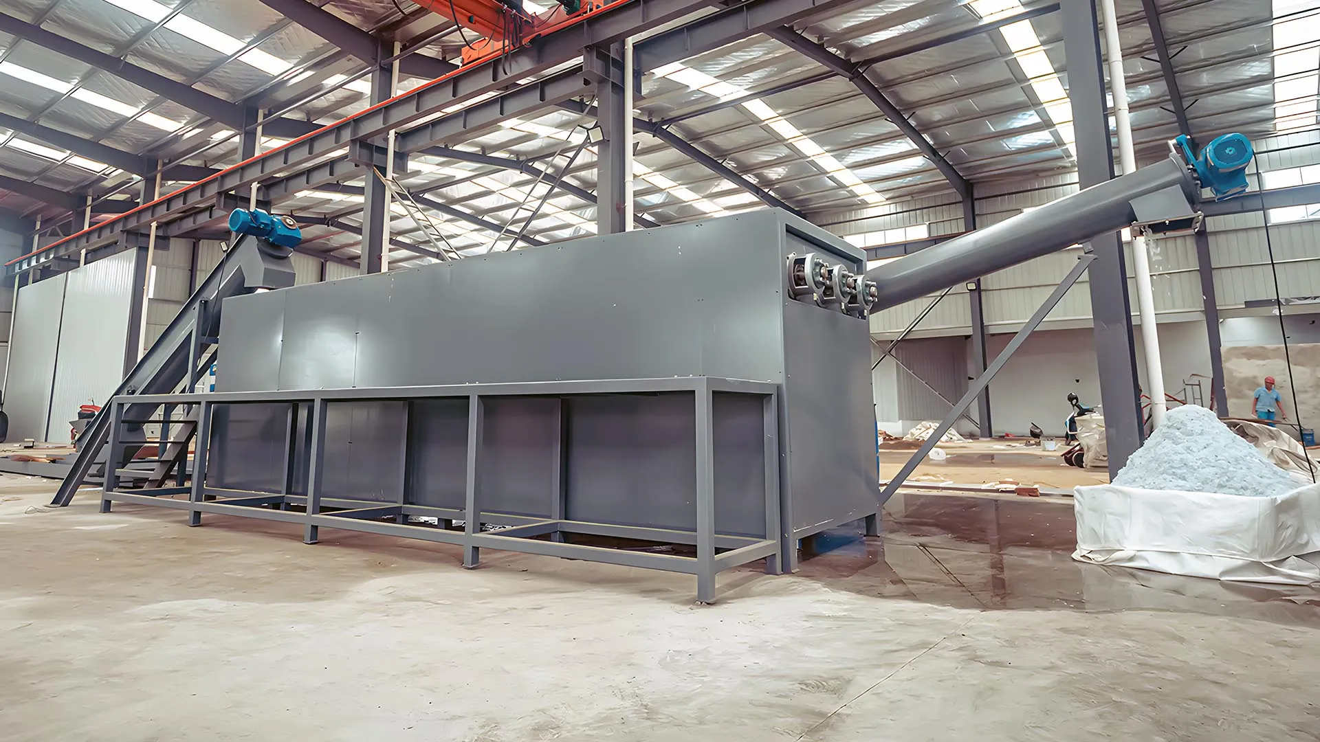 Tanque de separación por flotación de fregadero de triple fila industrial en una instalación de reciclaje, que muestra la gran estructura gris del equipo con tuberías y trabajadores que manejan materiales en un entorno de almacén espacioso