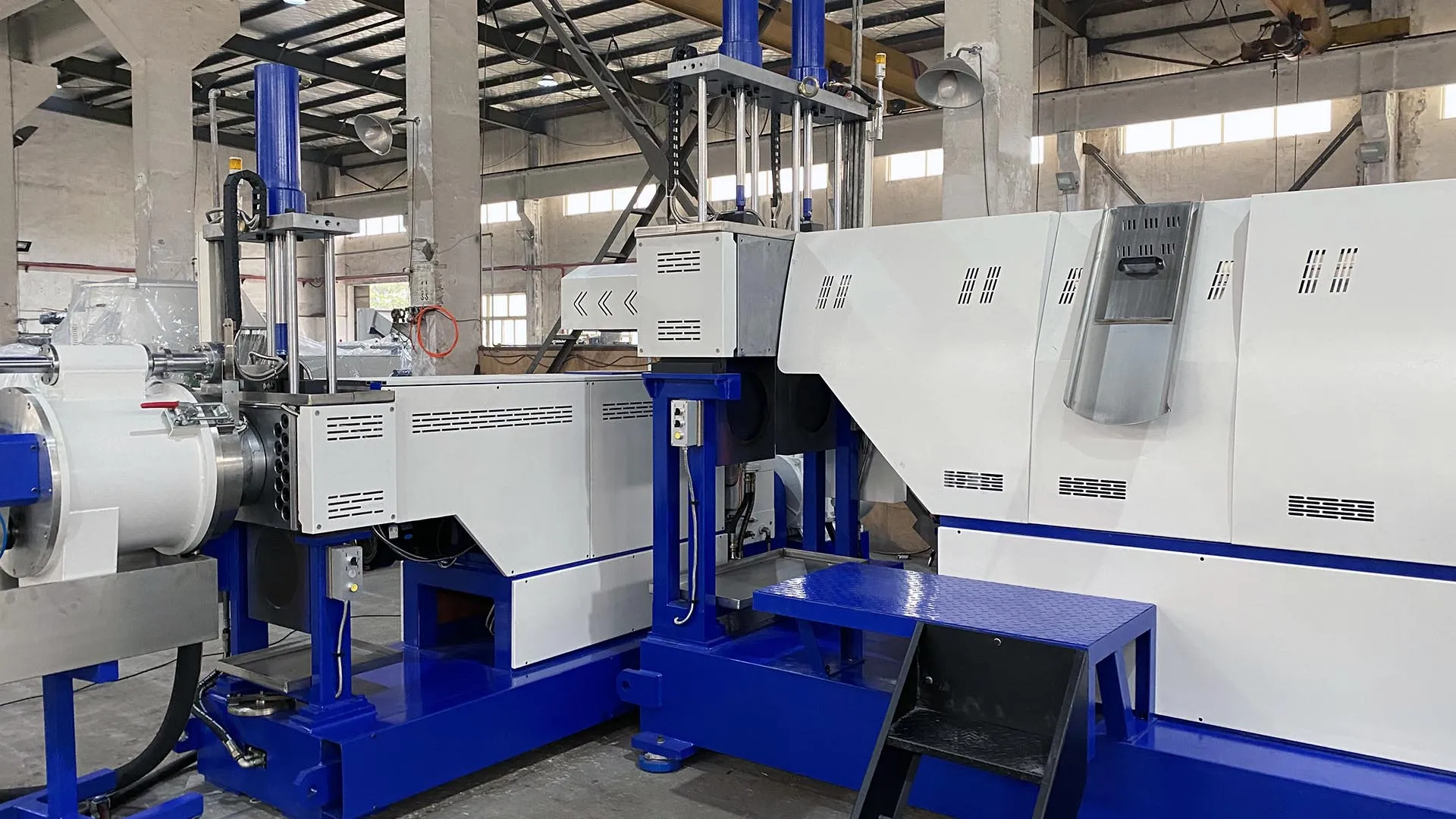 Advanced PP and HDPE rigid plastic flake pelletizing system in an industrial facility, featuring a blue and white color scheme with multiple modules and control mechanisms.