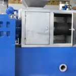 eine Schneckenpressen-Entwässerungsmaschine, die speziell für die Verarbeitung von PE-Folien entwickelt wurde. Die Maschine hat ein robustes, industrielles Design mit einem auffälligen blau-gelben Farbschema. Sie verfügt über einen vertikalen Zuführer an der Oberseite, durch den das Kunststoffmaterial in die Maschine eingeleitet wird, und einen horizontalen Schneckenpressenmechanismus, der in einem Metallgehäuse untergebracht ist. Das Gehäuse hat mehrere Türen, von denen eine offen ist und die innere Schneckenwelle und das äußere Rohr mit Perforationen zur Wasserableitung freigibt. Die Gesamtkonstruktion lässt auf eine intensive Nutzung zur effizienten Feuchtigkeitsentfernung beim Kunststoffrecycling oder ähnlichen industriellen Prozessen schließen.