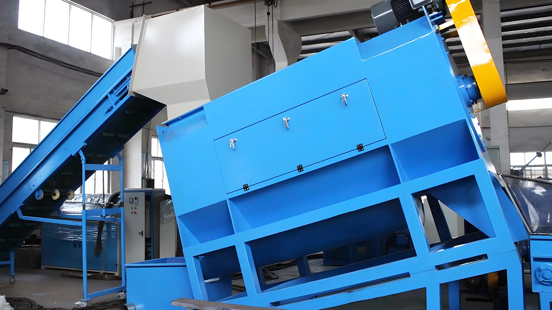 Wet plastic bottle label remover machine in a factory, designed for removing labels from plastic bottles during the recycling process.