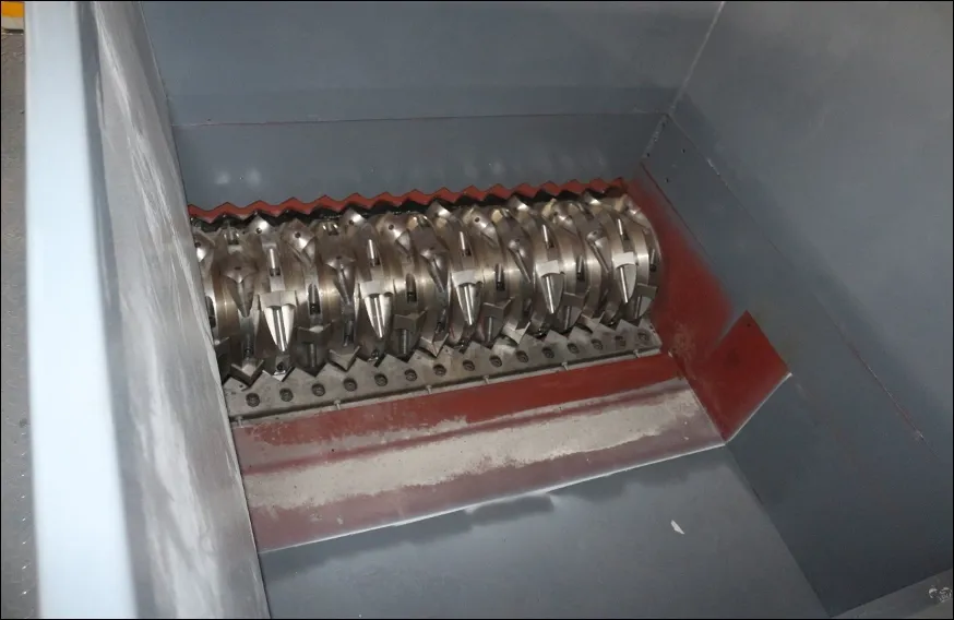 Industrial shredder with metal gears in enclosed space